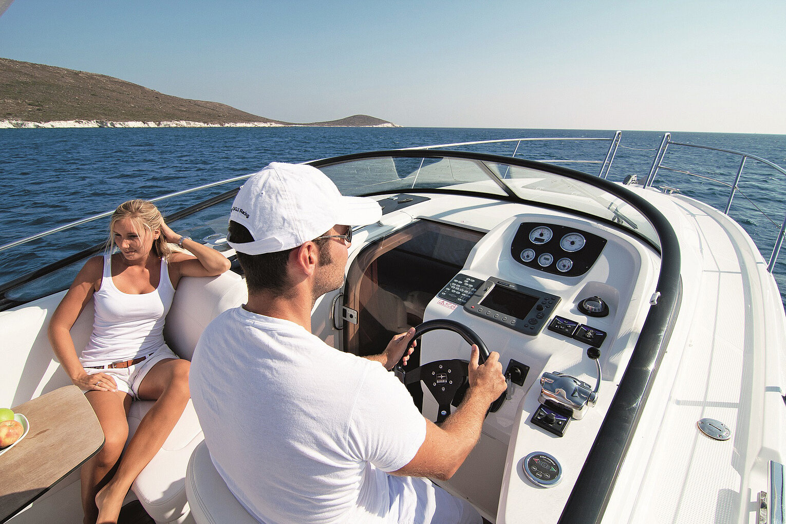 Mann steuert ein modernes Motorboot auf dem Bodensee bei sonnigem Wetter