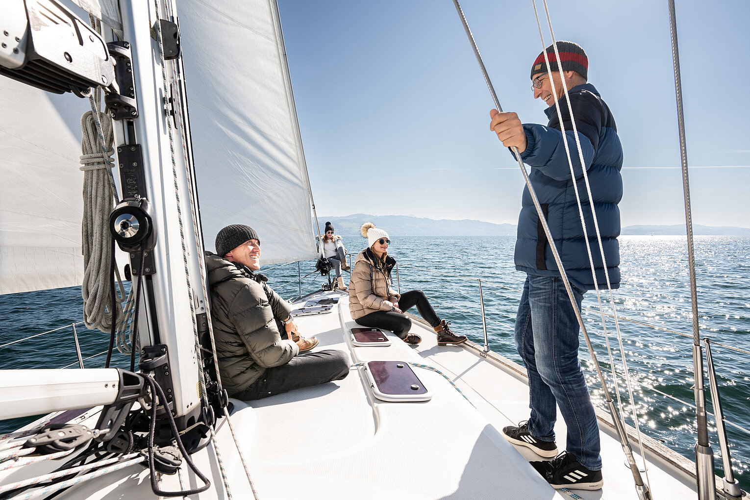 Crewmitglied steht auf dem Deck einer Segelyacht.