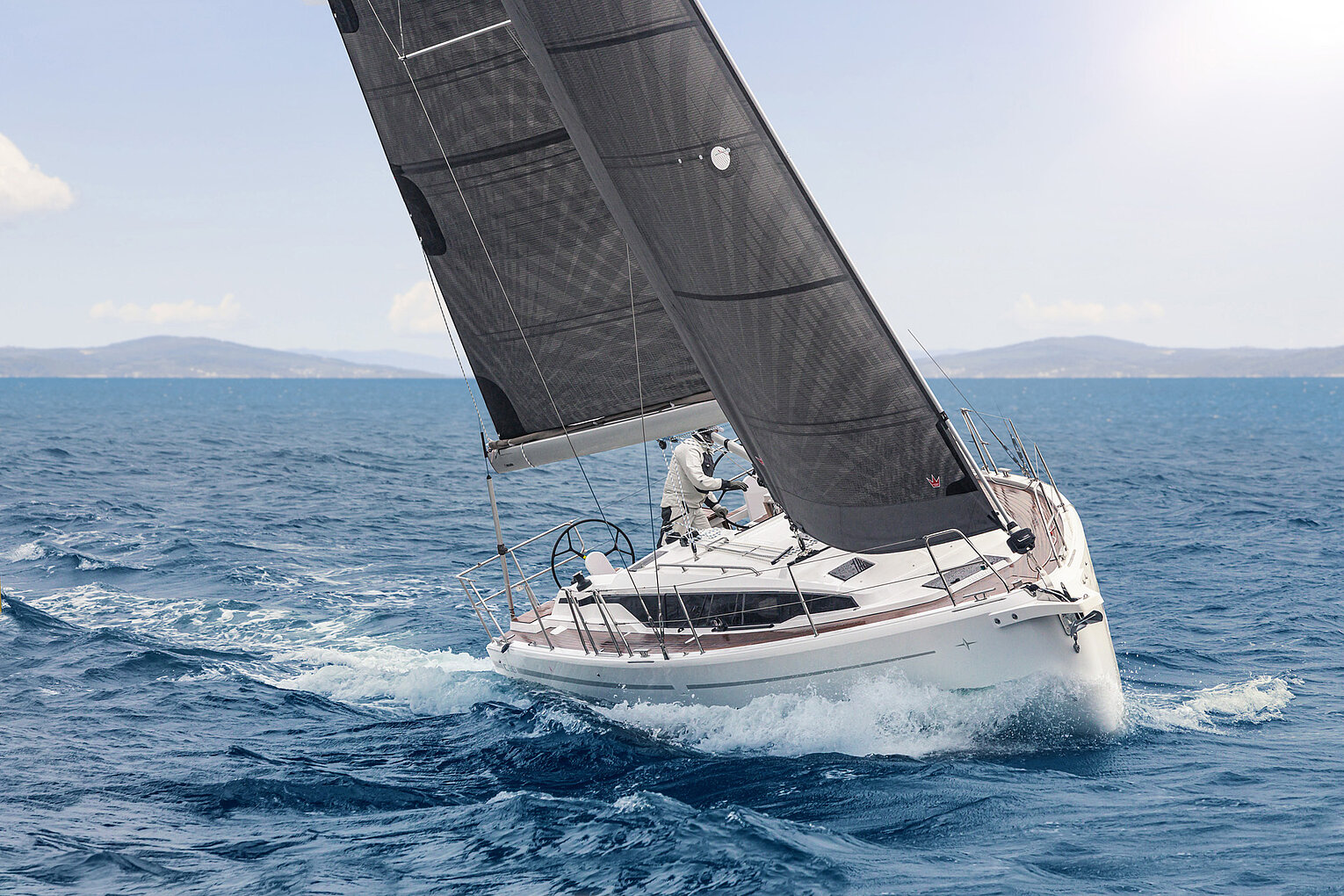 roße Segelyacht mit hoch aufragendem Mast und vollen Segeln auf dem Wasser